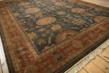 Terracotta border frames a dusty navy field with large palmettes on this Indian Bijar rug.