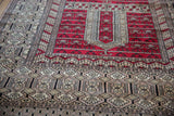 The vintage rug's intricate serpent borders meet the red field's Tree of Life design.