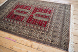Full perspective of a vintage Pakistani rug with a Turkmen prayer design in red and silver.