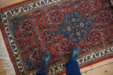 Showing the scale and plush pile of a vintage Ardebil rug with a brick red and sapphire blue Herati design.