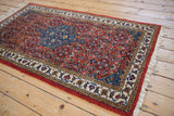 Angled view of the vintage Ardebil rug, highlighting its full pile, central medallion, and Herati field.