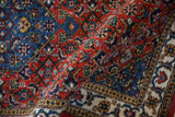 Folded view of the vintage Ardebil rug showing its plush, full pile and Herati design.