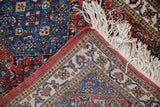 Hand-knotted back and secure selvage on a vintage Ardebil rug's corner with ivory fringe.