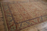 Angled view of a vintage Indian Bijar design carpet's floral border and fringe.