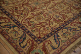 Corner of a vintage Indian carpet showing its scrolling leaf border and lustrous wool pile.