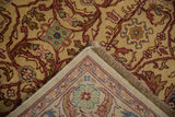 The rug's folded corner reveals the dense golden wool pile and its hand-knotted foundation.