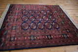 Angled perspective of a fine Bokhara rug showing the luster of its plush wool pile.