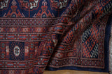 A draped view highlighting the lustrous wool pile and fine weave of a vintage Pakistani Bokhara rug.