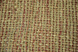 Woven texture of natural seagrass and jute rug with rustic red accents.