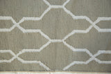 Modern sage green hand-woven rug with white geometric trellis pattern.