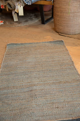 Detail of the hand-woven Cate Jute rug's blended gray and blue textured fibers.