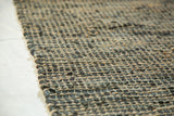 Chunky hand-woven texture of the Clay rug, blending dark recycled leather and natural jute.