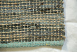 Clay Collection modern textural weave of recycled leather and natural jute with teal border.