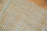 Chunky woven jute rug texture featuring subtle blue-gray and natural beige threads.