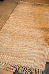 Natural jute rug detail, showing its handwoven texture and fringe.