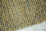 Lily rug's coarse, handmade weave of natural seagrass and blue jute fibers with raw edge.