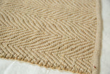 Textured herringbone weave of natural seagrass and recycled PET yarn.