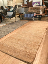 Jute rug close-up highlighting natural woven texture with subtle color striations.