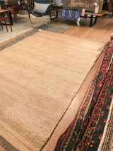 Close-up of natural jute rug showing its plain weave texture and varying tones.