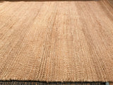 Textural detail of a natural jute rug showcasing its plain weave and tonal striations.