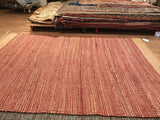 Handwoven red and natural striped jute texture with distinct natural border and tag.