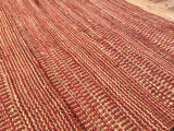 Textured hand-woven Razz jute rug, showcasing reddish-brown and natural striped pattern.