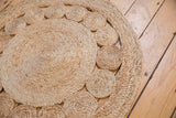 Close-up of hand-woven natural jute rug with braided coiled circles.