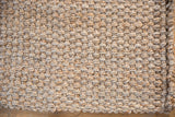 Chunky hand-woven jute texture in natural light beige and brown shades.