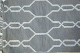 Selma Collection rug with gray flatweave texture, white geometric pattern, and fringe.