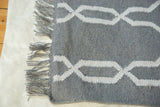 Hand-woven gray Selma rug with white geometric interlocking pattern and fringe.