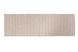 Hand-woven rug corner with gray and white textured vertical stripes.