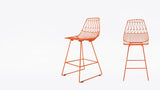 Orange Lucy counter stools, showing modern wire design with geometric backrests.