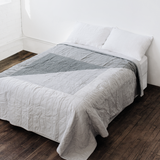 Textured dark and light gray geometric design on a queen quilt.