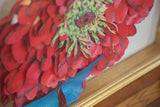 Textured ruby red flower petals, vibrant green center, blue butterfly wing, gold frame detail.