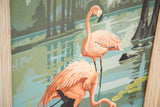 Detail of faded coral flamingos in vintage paint by numbers artwork, with wood frame.