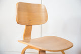 Curved light wood back and seat on a vintage Thonet style side chair.