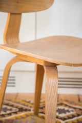 Curved light wood seat and bentwood frame of a vintage Thonet style chair.
