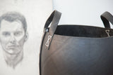Recycled rubber basket, black textured exterior with white stitching detail and handle.