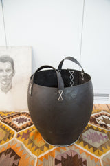 Bottom detail of the industrial black recycled rubber basket with white stitching.