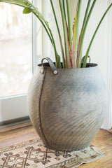 Side view of oversized recycled rubber basket, showing industrial tire tread texture and leather handle.