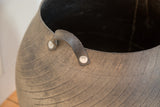 Recycled rubber basket detail showing textured handle, metal rivets, and tire tread.