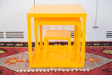 Close view of nested retro tangerine orange storage cubes, revealing surface wear.