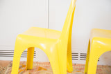 Curved backrest and seat of a glossy bright yellow Borg Wagner chair.