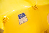 Close-up of the bright yellow Borg Warner chair's underside, showing the Marbon Cycolac label.