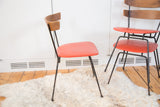 Side profile of Pascoe chair, curved Birchwood back and bright orange vinyl seat.