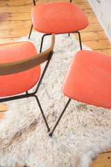 Vintage orange vinyl seats and black iron legs of Mid Century chairs.