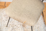 Clifford Pascoe chair seat, showing textured gray vinyl with a small edge tear.