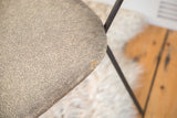 Close-up of vintage Clifford Pascoe chair seat, textured gray vinyl with slight marking.