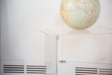 Clear Lucite top surface of vintage rolling cart, showing faint marks.