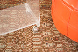Vintage Lucite rolling cart detail, showing clear tabletop corner and chrome caster wheel.